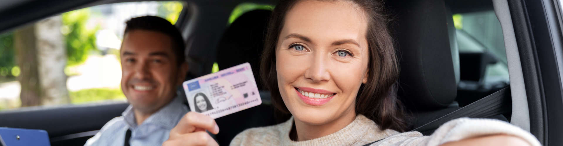 woman with license and driving school instructor